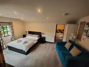 a bedroom with a bed and a blue couch at The Garden Lodge in Llynclys