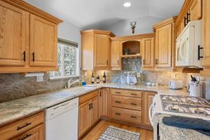 una cocina con armarios de madera y electrodomésticos blancos en Cozy Cabin perfect for 2 Families en Big Bear Lake
