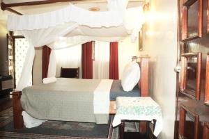 The Embassy Residence في مومباسا: غرفة نوم بسرير مع مظلة +68 صورة