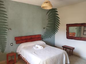 1 dormitorio con un gato blanco en la cama en Calli Sofi Posada, en Tepoztlán