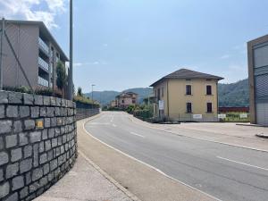 an empty street with a stone wall next to a building at Appartamento di 45mq a Balerna in Balerna