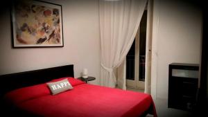 1 dormitorio con cama roja y ventana en Napulè, en Nápoles