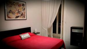 una camera da letto con un letto rosso e una finestra di Napulè a Napoli
