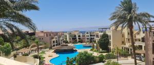a view of a resort with a pool and palm trees at Flat One room apartment in talabay aqaba in Al Burj