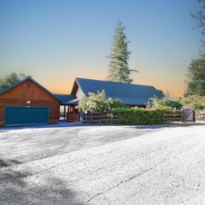 a house with a barn with a blue garage at Log cabin oasis with spectacular views & stargazing in Mariposa