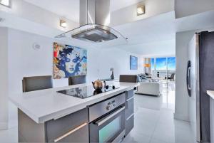 cocina con encimera blanca y nevera en Bay Watch Penthouse! Direct Water Views!, en Miami