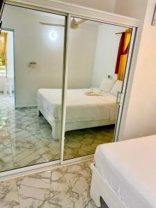 - une chambre avec un lit et un miroir dans l'établissement Apartamentos felix Las terrenas, à Las Terrenas