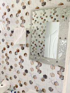 espejo de baño con conchas en la pared en Apartamentos felix Las terrenas en Las Terrenas