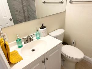 a bathroom with a sink and a toilet and a mirror at Minutes to the River Walk and the Alamo Pet Friendly Sleeps 8! in San Antonio
