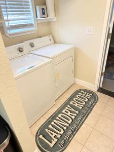 uma cozinha com uma máquina de lavar roupa e um tapete no chão em Minutes to the River Walk and the Alamo Pet Friendly Sleeps 8! em San Antonio