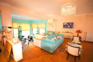 Aethrio Guesthouse في سوفالا: غرفة معيشة مع أريكة زرقاء وطاولة
