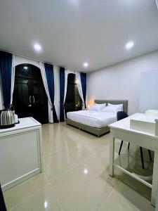 a bedroom with two beds and a table in it at คีรีศิลป์ รีสอร์ท เชียงราย (Khirisin Resort Chiang rai) in Ban Nong Salaep