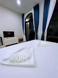 Una cama blanca con dos toallas blancas. en คีรีศิลป์ รีสอร์ท เชียงราย (Khirisin Resort Chiang rai), en Ban Nong Salaep
