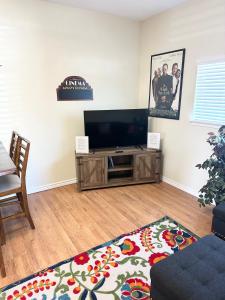 a living room with a flat screen tv and a table at Minutes to Riverwalk, Sleeps 12, Pets Welcome! in San Antonio