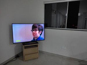 a flat screen tv sitting on a stand in a room at Pousada Gomes in Itaobim