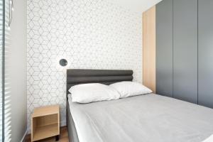a bedroom with a bed with a white bedspread at Riverside Apartments by KRAMM in Poznań