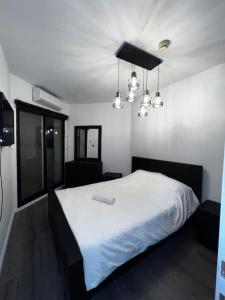 een slaapkamer met een groot wit bed met verlichting bij Lake Breeze of Tiberias in Tiberias