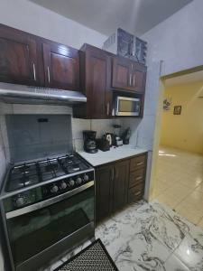 a kitchen with wooden cabinets and a stove top oven at Single Room on Farcas Drive in Mammee Bay