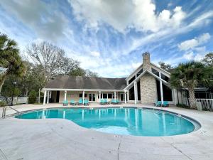 a large swimming pool in front of a house at Nomad Retreat King Bed Boutique Condo w Garage in Gainesville