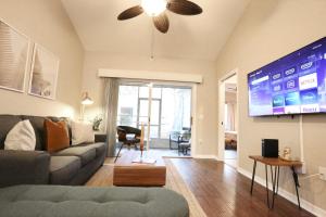 a living room with a couch and a flat screen tv at Nomad Retreat King Bed Boutique Condo w Garage in Gainesville