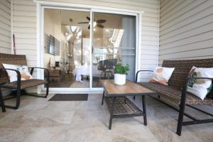 a porch with two benches and a wooden table at Nomad Retreat King Bed Boutique Condo w Garage in Gainesville