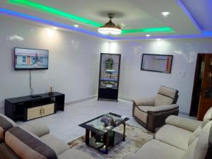 ダカールにあるAppartement 3 chambres toutes climatisées à virageのソファと椅子とテーブルのあるリビングルーム