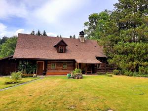 a log cabin with a yard and a house at Apartmán Roubenka Všemily in Jetřichovice