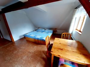 Kleines Zimmer mit einem Bett und einem Tisch in der Unterkunft Apartmán Roubenka Všemily in Jetřichovice