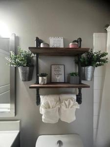 a bathroom with a shelf with towels and plants at SAVINGS ON WKLY & MTHLY STAYS! N Heart Of Dallas! in Dallas