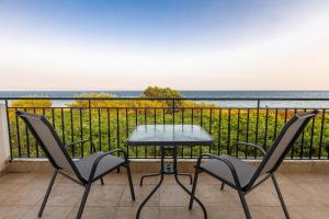 a table and chairs on a balcony with the ocean at Seaheaven houses B4 in Koroni