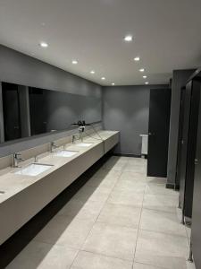 ein Badezimmer mit vier Waschbecken und einer Spiegelreihe in der Unterkunft Tual bahçekent 1+1 studio in Basaksehir