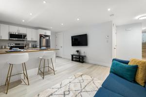 a living room with a blue couch and a kitchen at Beautiful 1 bedroom apartment - private entrance in Moncton