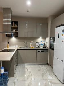 uma cozinha com um lavatório e um frigorífico branco em Tual bahçekent 1+1 studio em Basaksehir