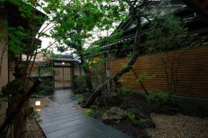 een tuin met een stenen loopbrug voor een gebouw bij willow. in Toyooka