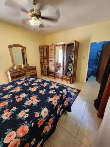 a bedroom with a bed with a floral bedspread at Single Room on Farcas Drive in Mammee Bay