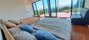 uma sala de estar com duas camas e um sofá em บ้านไร่ระเบียงฟ้า น้ำหนาว แคมป์ปิ้ง em Ban Phu Hi