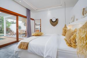 een slaapkamer met een groot wit bed en een patio bij Villa Karina - Sumptuous 1BR Private Luxury Villa Walking Distance to Nyanyi Beach in Tabanan +25 foto's