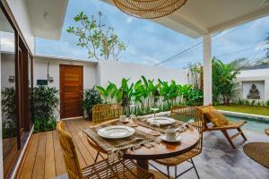 een eetkamer met een tafel en stoelen op een terras bij Villa Karina - Sumptuous 1BR Private Luxury Villa Walking Distance to Nyanyi Beach in Tabanan