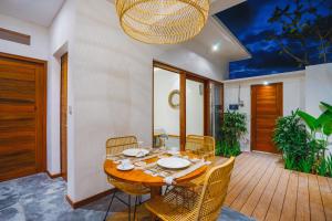 een eetkamer met een houten tafel en stoelen bij Villa Karina - Sumptuous 1BR Private Luxury Villa Walking Distance to Nyanyi Beach in Tabanan