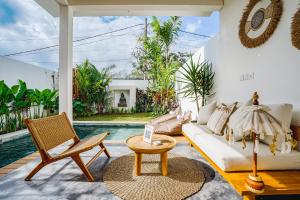 een woonkamer met een witte bank en een tafel bij Villa Karina - Sumptuous 1BR Private Luxury Villa Walking Distance to Nyanyi Beach in Tabanan