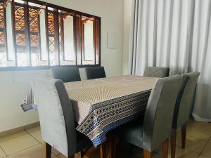 uma mesa de jantar com cadeiras e uma toalha de mesa em Casa aconchegante com piscina em Macapá