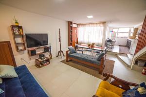 sala de estar con sofá azul y TV en Departamento completo - Los Ubi, en Baños