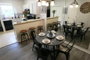 una sala da pranzo con tavoli e sedie e una cucina di Renovated Modern Industrial Suite 2 BR Condo a Gainesville