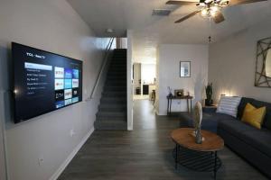 a living room with a couch and a tv on a wall at Renovated Modern Industrial Suite 2 BR Condo in Gainesville