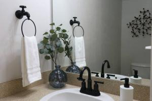 a bathroom counter with a sink and a mirror at Renovated Modern Industrial Suite 2 BR Condo in Gainesville
