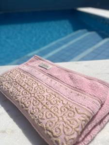 uma toalha rosa sentada ao lado de uma piscina em Casa aconchegante com piscina em Macapá