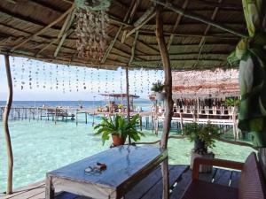 een tafel op het strand met uitzicht op de oceaan bij Yenbainus homestay in Yennanas Besir +37 foto's