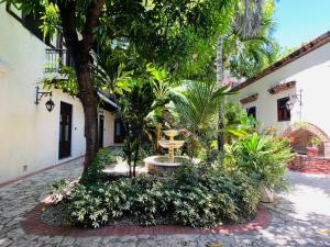 cortile con alberi e piante di fronte a un edificio di Paseo Colonial - Leo's Favorite a Santo Domingo