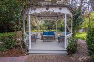 a gazebo with blue chairs and a bench at Kaleidoscope Inn & Gardens in Nipomo