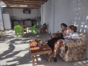 2 personas sentadas en sillas en una sala de estar en 420 Route's Backpackers en Nazca